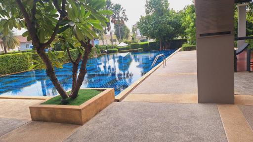 Outdoor area with swimming pool and lush greenery