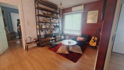 Cozy living room with wooden flooring and a brick accent wall