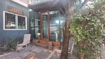 Modern building entrance with large glass doors and a serene garden setting