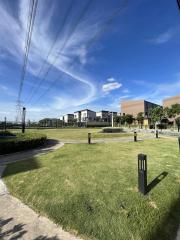 Expansive view of a residential area with modern houses, green lawns, and clear blue skies