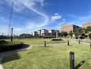 Expansive view of a residential area with modern houses, green lawns, and clear blue skies