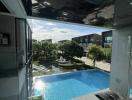 View from a high-rise building showing a swimming pool and surrounding garden area