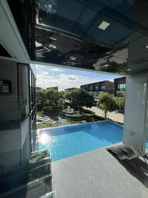 View from a high-rise building showing a swimming pool and surrounding garden area