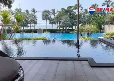Tranquil outdoor swimming pool area with lush greenery and wooden deck