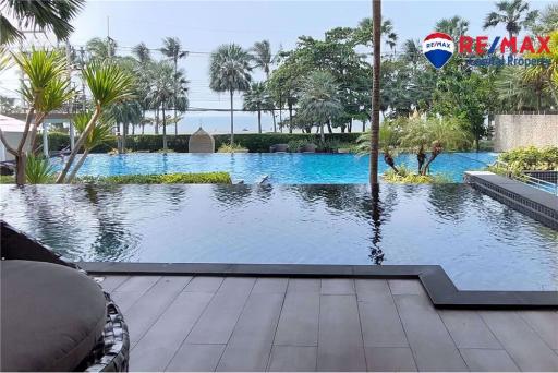 Tranquil outdoor swimming pool area with lush greenery and wooden deck