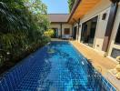 Private swimming pool with tropical garden in a residential villa