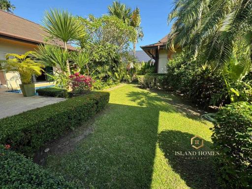 Lush green garden with manicured lawn and tropical plants