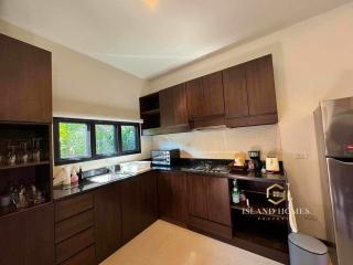 Modern kitchen with dark wooden cabinets and stainless steel appliances