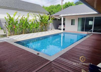 Spacious backyard with a swimming pool and wooden deck
