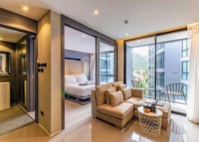 Modern bedroom with attached bathroom and balcony access featuring a comfortable seating area