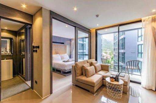 Modern bedroom with attached bathroom and balcony access featuring a comfortable seating area