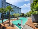 Swimming pool area with lounging deck and residential building in the background