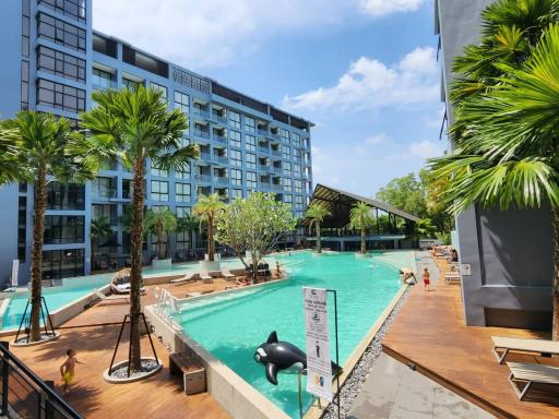 Swimming pool area with lounging deck and residential building in the background