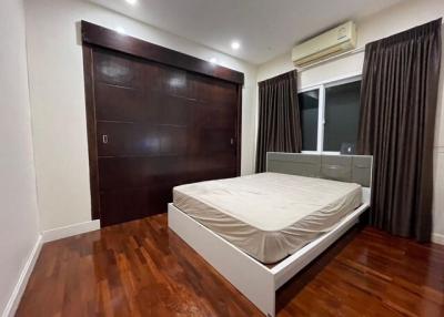 Spacious bedroom with hardwood floors and modern furnishings