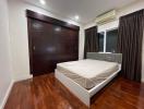 Spacious bedroom with hardwood floors and modern furnishings