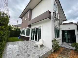 Exterior view of a modern two-story house with patterned patio and landscaping