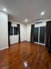 Spacious bedroom with wooden flooring and ample overhead lighting