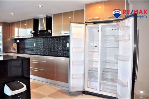 Modern kitchen with stainless steel appliances and dark backsplash
