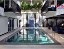 Indoor residential swimming pool with surrounding walkway and balcony