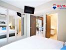 Spacious bedroom with mirrored closet doors and view into adjoining rooms