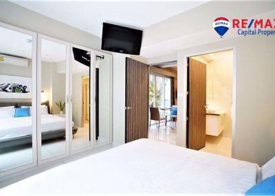 Spacious bedroom with mirrored closet doors and view into adjoining rooms