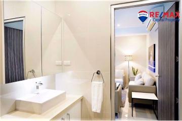 Modern bathroom with clean design and a glimpse into the adjoining living area