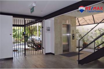 Spacious and modern building entrance with natural light, plants, and elevator access