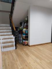 Modern staircase area with wooden floors and storage shelves