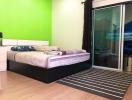 Modern bedroom with bright green accent wall and sliding closet doors