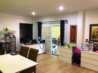 Spacious living room with office setup and sliding doors leading to the balcony