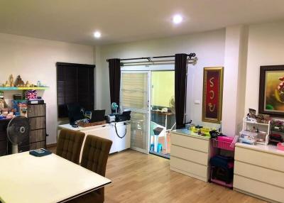 Spacious living room with office setup and sliding doors leading to the balcony