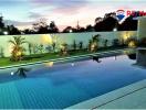 Well-maintained outdoor swimming pool with ambient lighting and landscaped garden