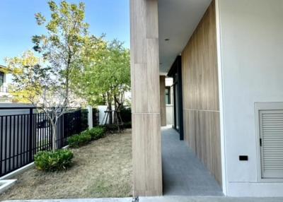 Modern exterior walkway with wooden wall cladding and concrete pathway