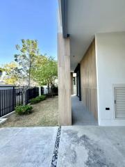 Modern exterior walkway with wooden wall cladding and concrete pathway