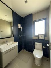 Modern bathroom with blue tiles, white fixtures, and natural light