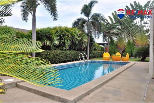 Outdoor swimming pool surrounded by tropical vegetation