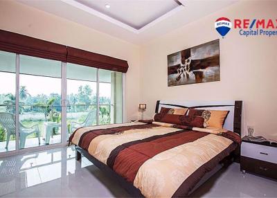Spacious bedroom with large windows and view of nature