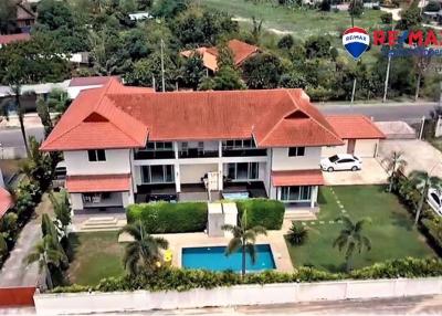 Aerial view of a two-story residential house with red roof and swimming pool