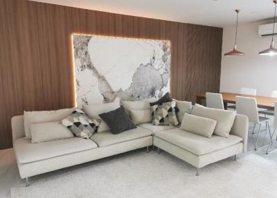 Modern living room with designer couch and elegant stone wall feature