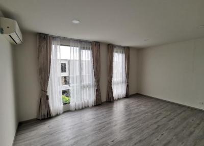 Spacious unfurnished living room with large windows and hardwood flooring