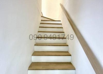 Bright staircase with white walls and wooden stairs in a modern home
