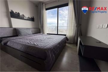 Spacious bedroom with large bed and city view