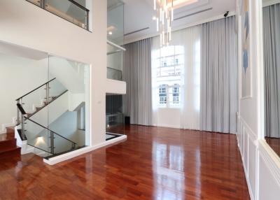 Spacious double-height living room with staircase and large windows