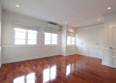 Spacious and well-lit living room with hardwood floors and multiple windows