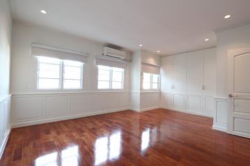 Spacious and well-lit living room with hardwood floors and multiple windows