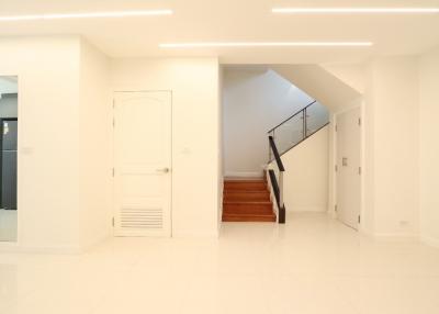 Spacious building interior with bright lighting, a staircase, and glossy tiled flooring
