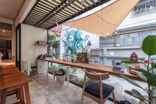 Modern patio area with wooden dining table and artistic wall mural