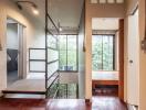 Modern hallway with stairs and large windows showing greenery outside