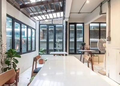 Spacious industrial-style living area with high ceiling and ample natural light
