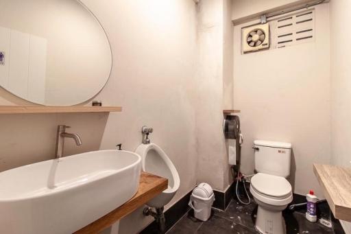 Compact bathroom with white fixtures and wooden accents